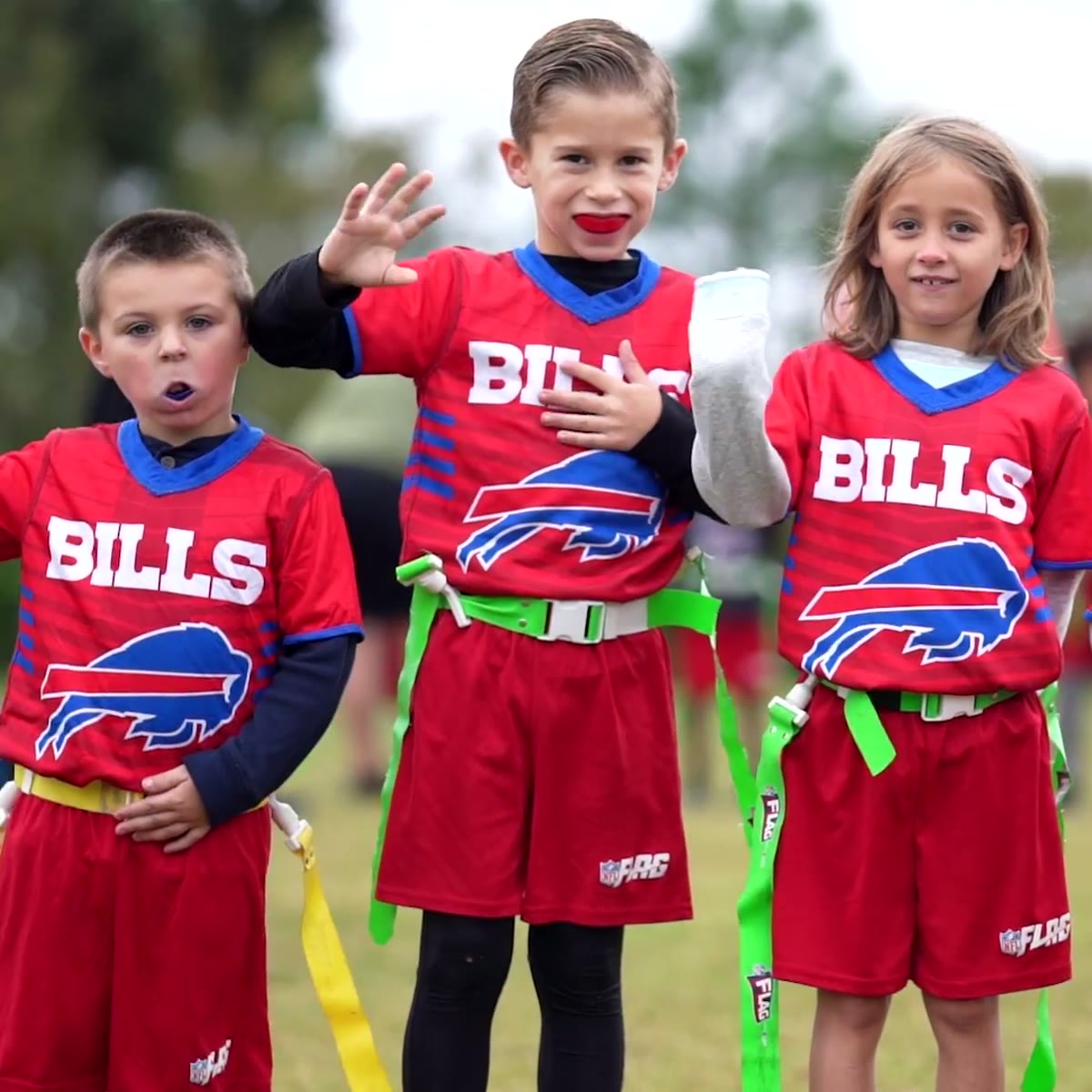 Three young players in Bills jerseys on the sideline
